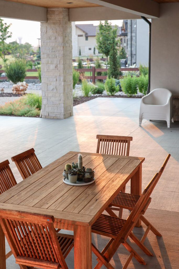 A large patio space with a wooden table and chairs.