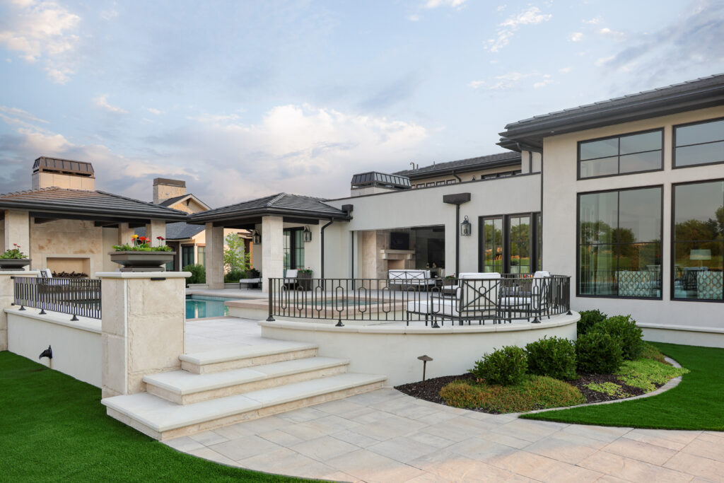The back patio of a house with a pool and patio furniture.