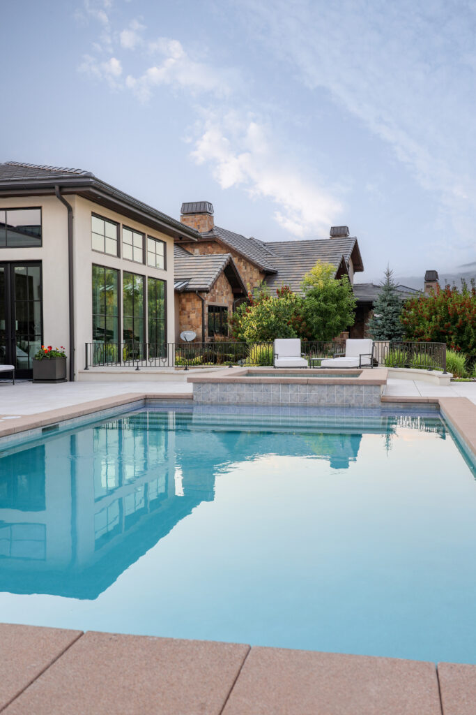 The outside of a house with a beautiful blue swimming pool.