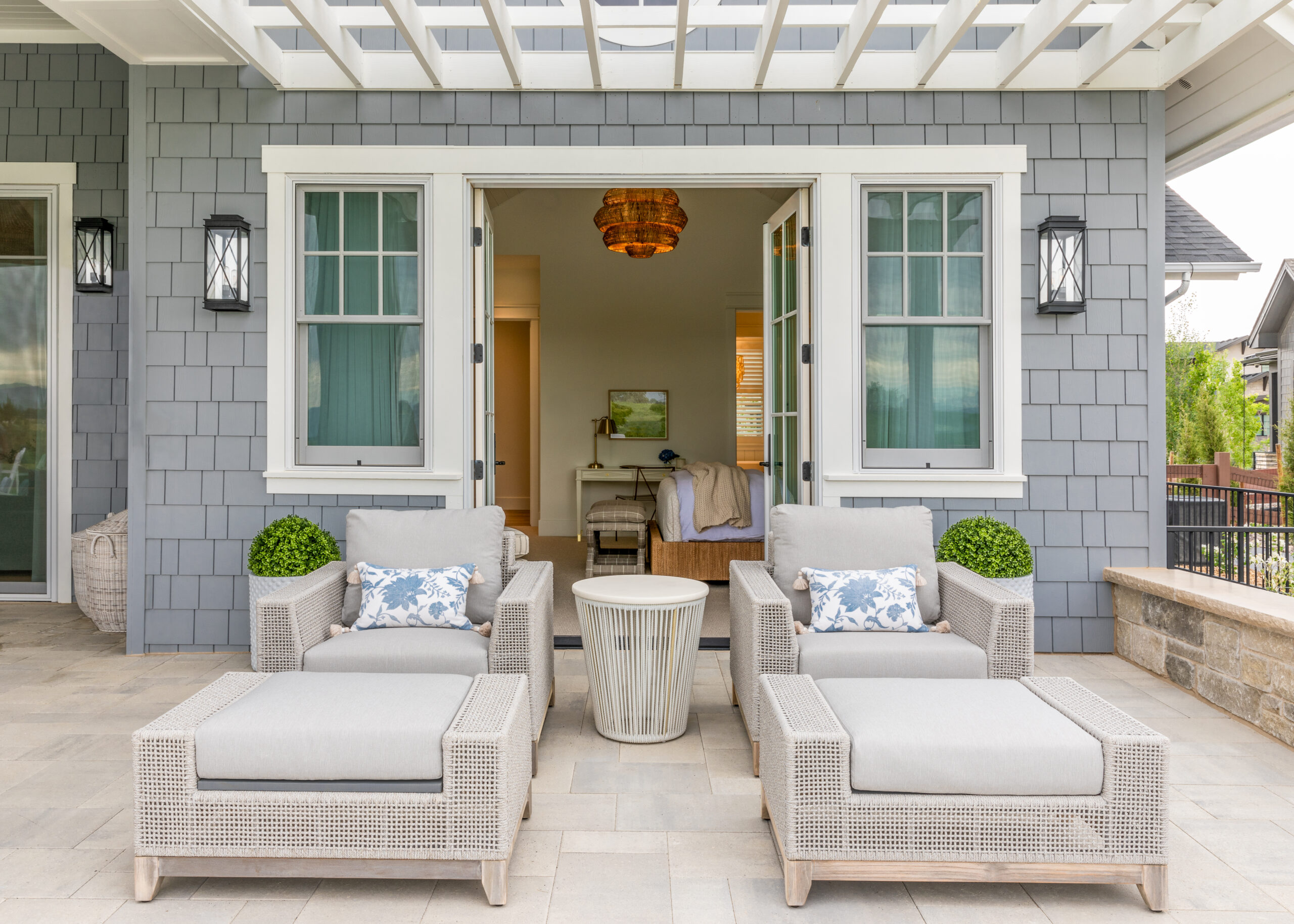 A patio with beautiful patio chairs with white and blue pattern and open interior doors.