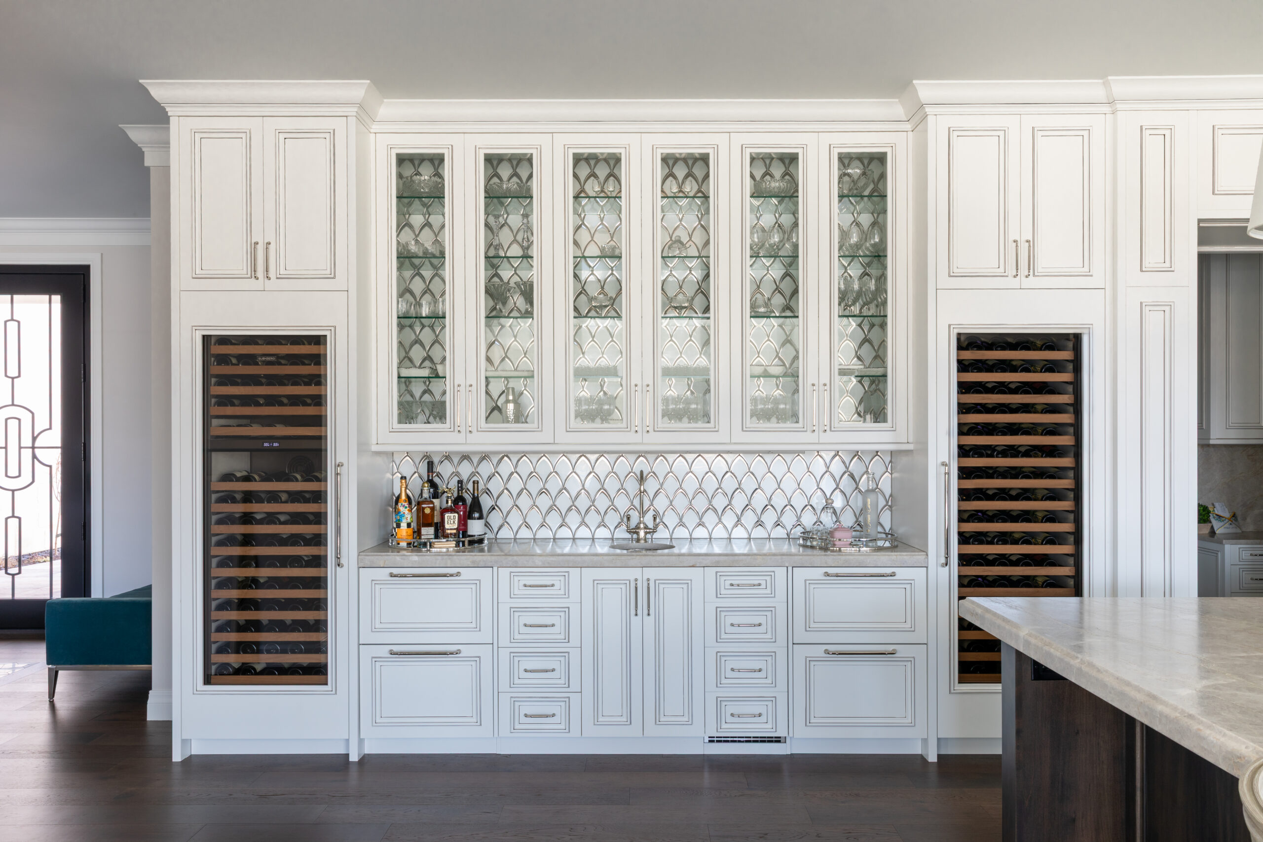 Large white cabinets with patterned windows in a spacious kitchen.